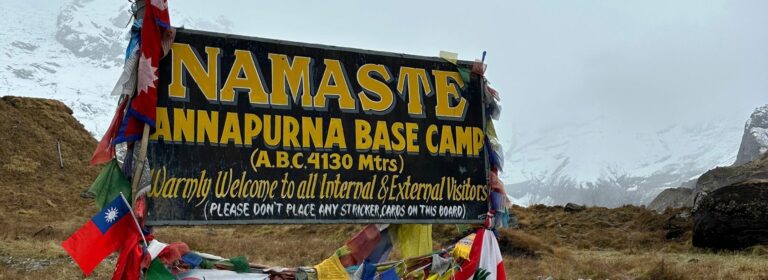 ABC trek signboard stands above snow trail