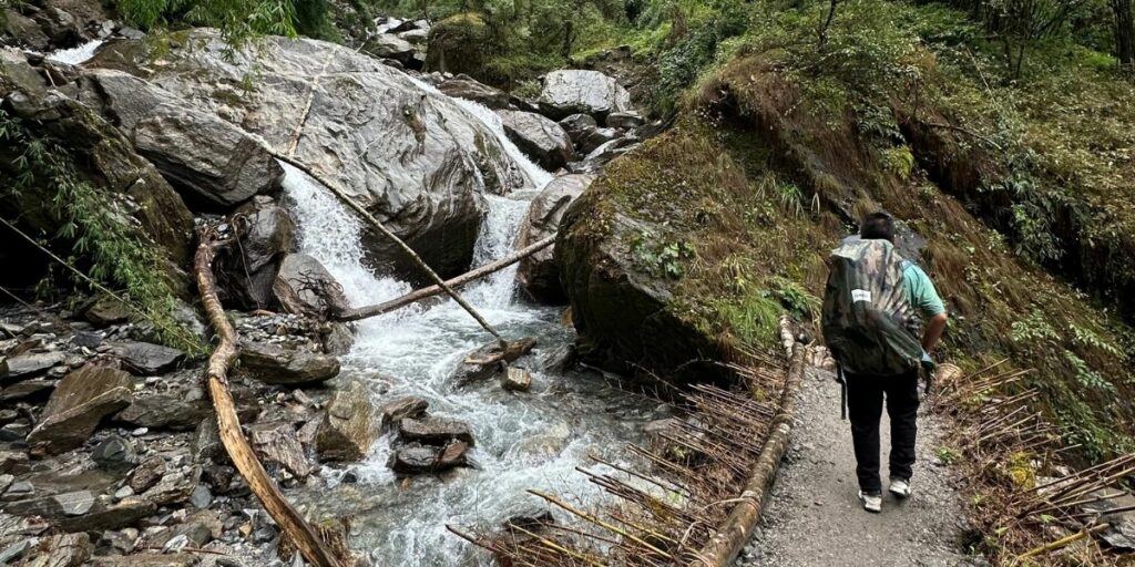 Backpackers navigate wet forest trail in Annapurna