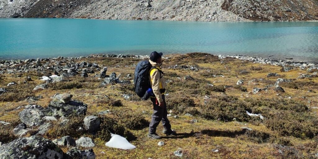 Trekker near turquoise lake on EBC trail