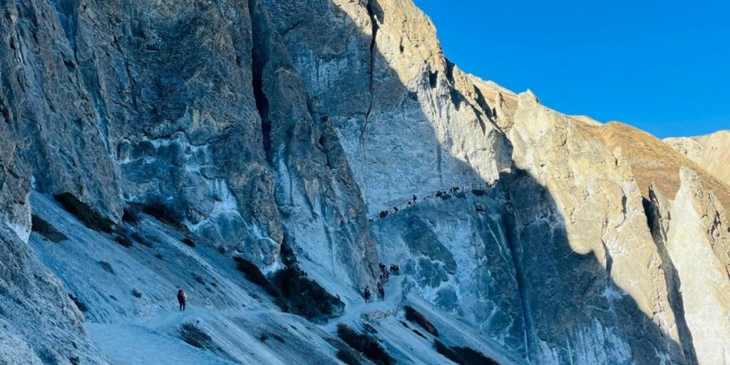 Trekkers navigating a rugged trail surrounded by pristine mountain views