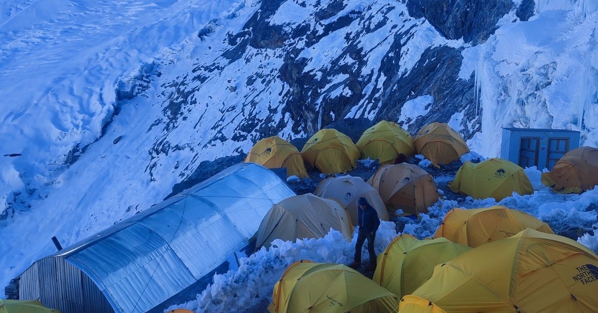 base camp tents with heavy snow backdrop in everest summit expedition