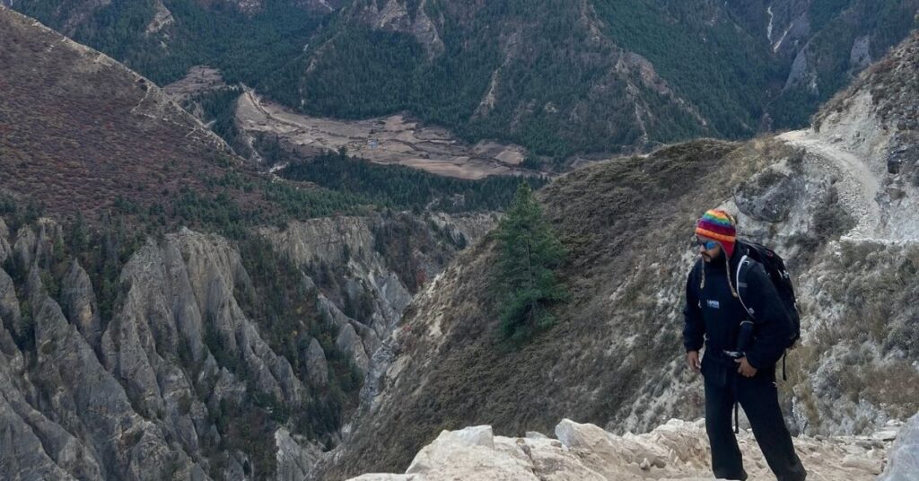 Hiker enjoying panoramic Himalayan views on a high-altitude trail