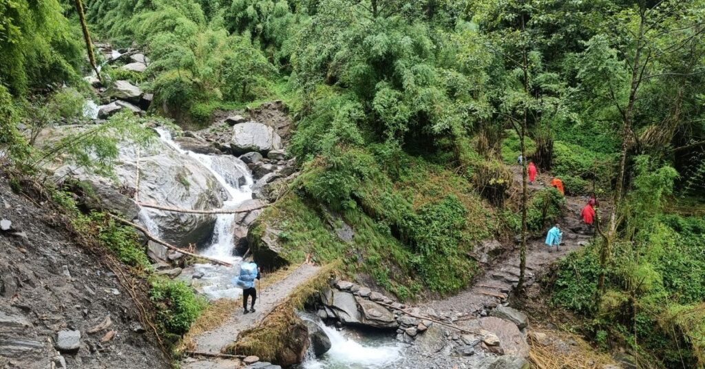 Jungle trail in Nepal leading past waterfalls and stone pathways