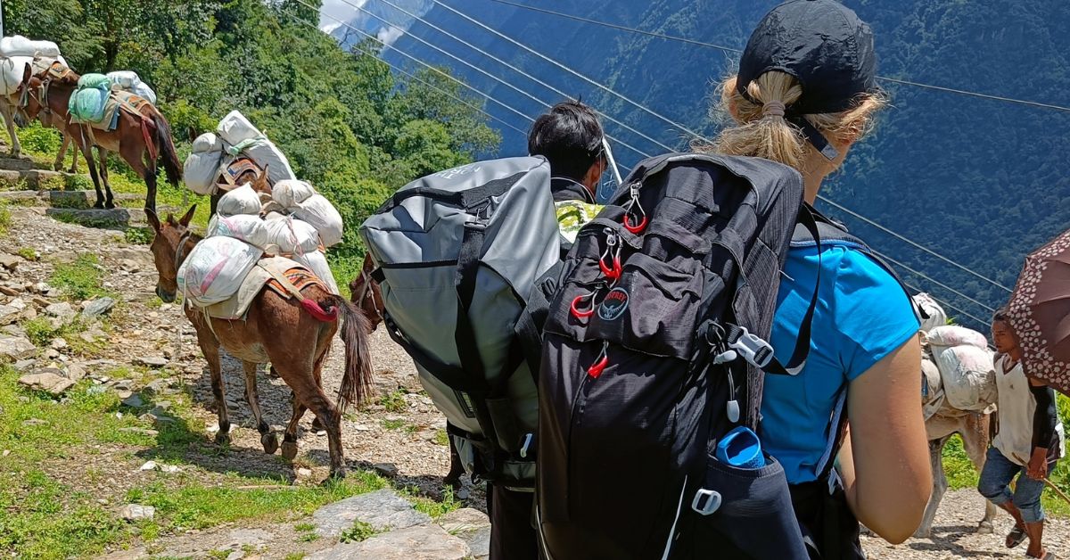 Trekkers beginning ABC trek Day 1 from Jhinu Danda trailhead with guide and porters