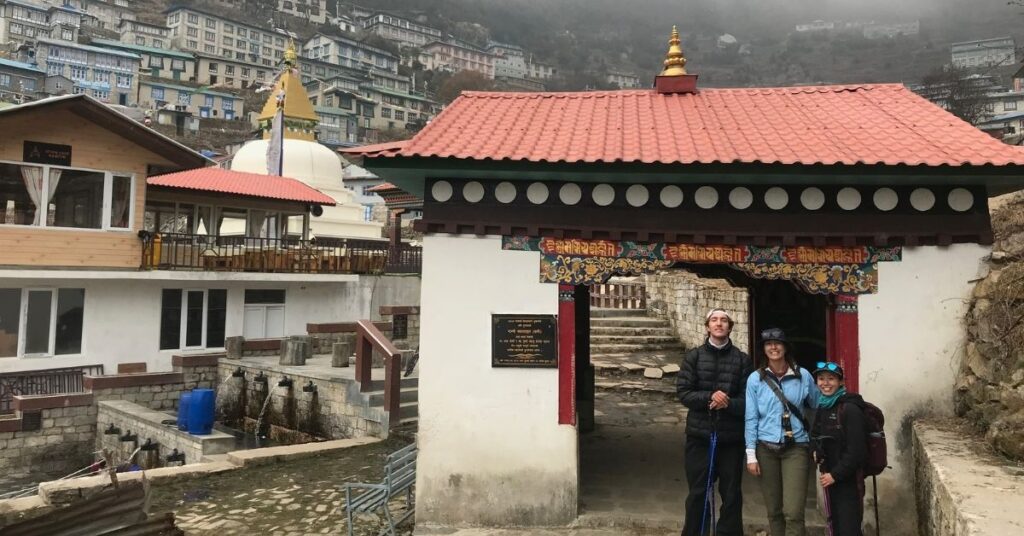Trekkers posing at the entrance gate of Namche Bazaar Monastery
