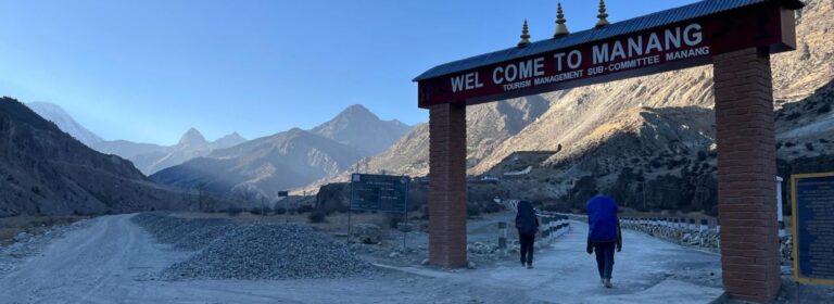 Welcome gate of Manang Village with trekkers entering the region