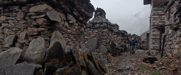 Ancient stone chortens and mani walls along a village trail in Tsum Valley