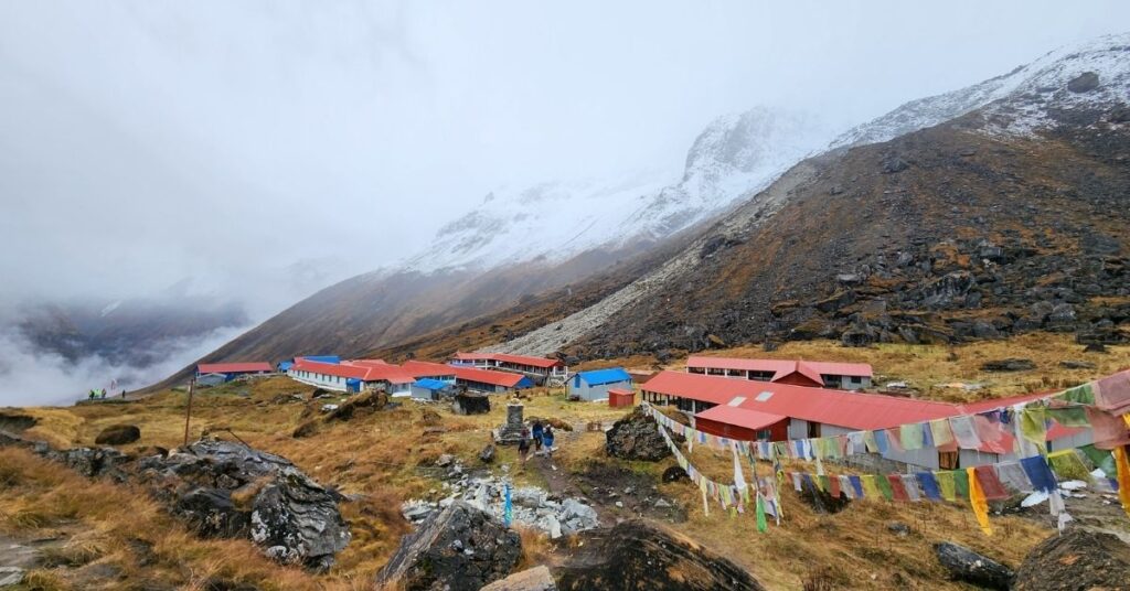 Annapurna Base Camp lodges surrounded by snowy peaks and prayer flags
