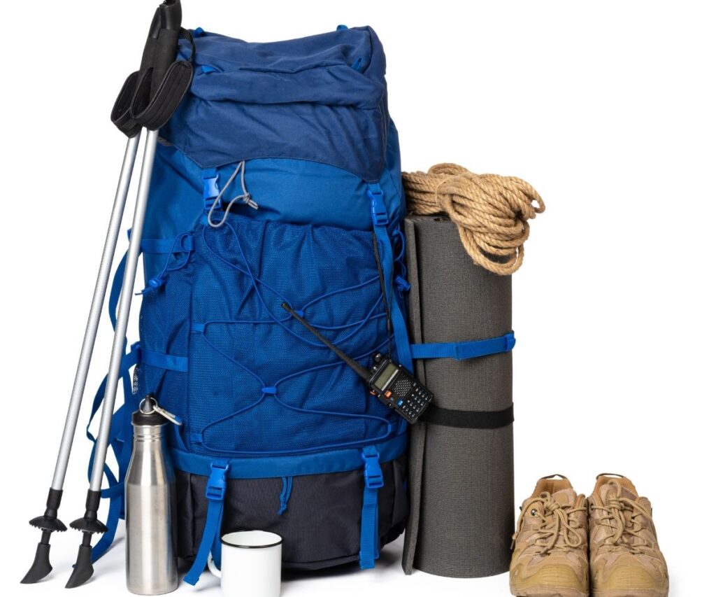 Essential hiking gear with backpack, shoes, and trekking poles ready for Nepal trails
