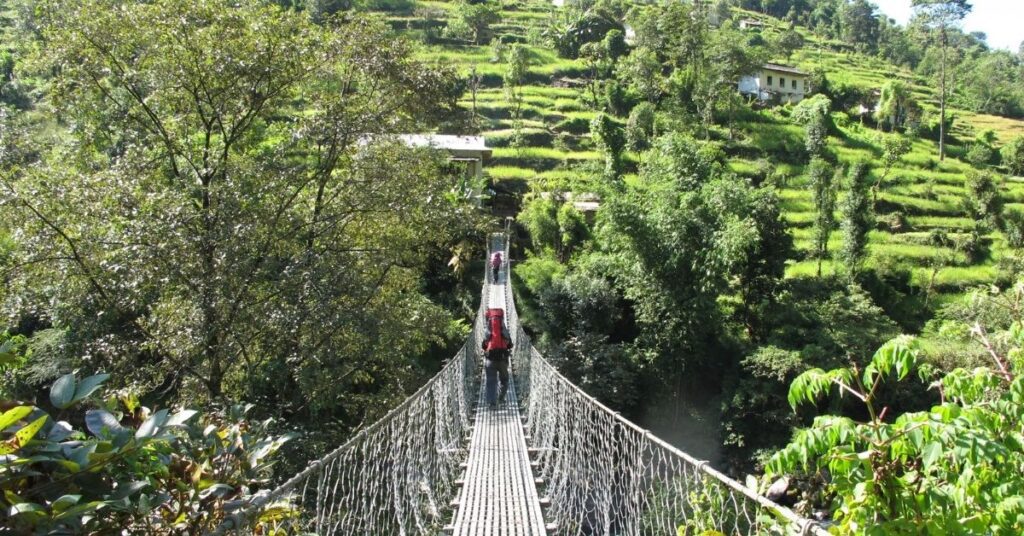 Suspension bridge crossing through green hills on the way to Everest Base Camp