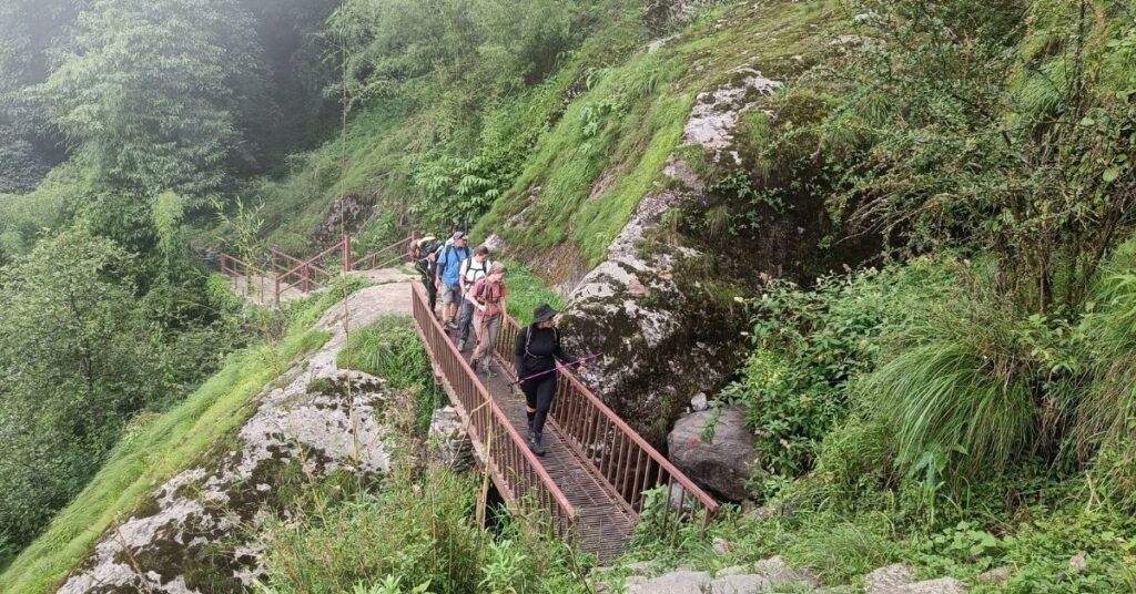 trekkers passing through a small bridge on the journey to 5 days ABC trek