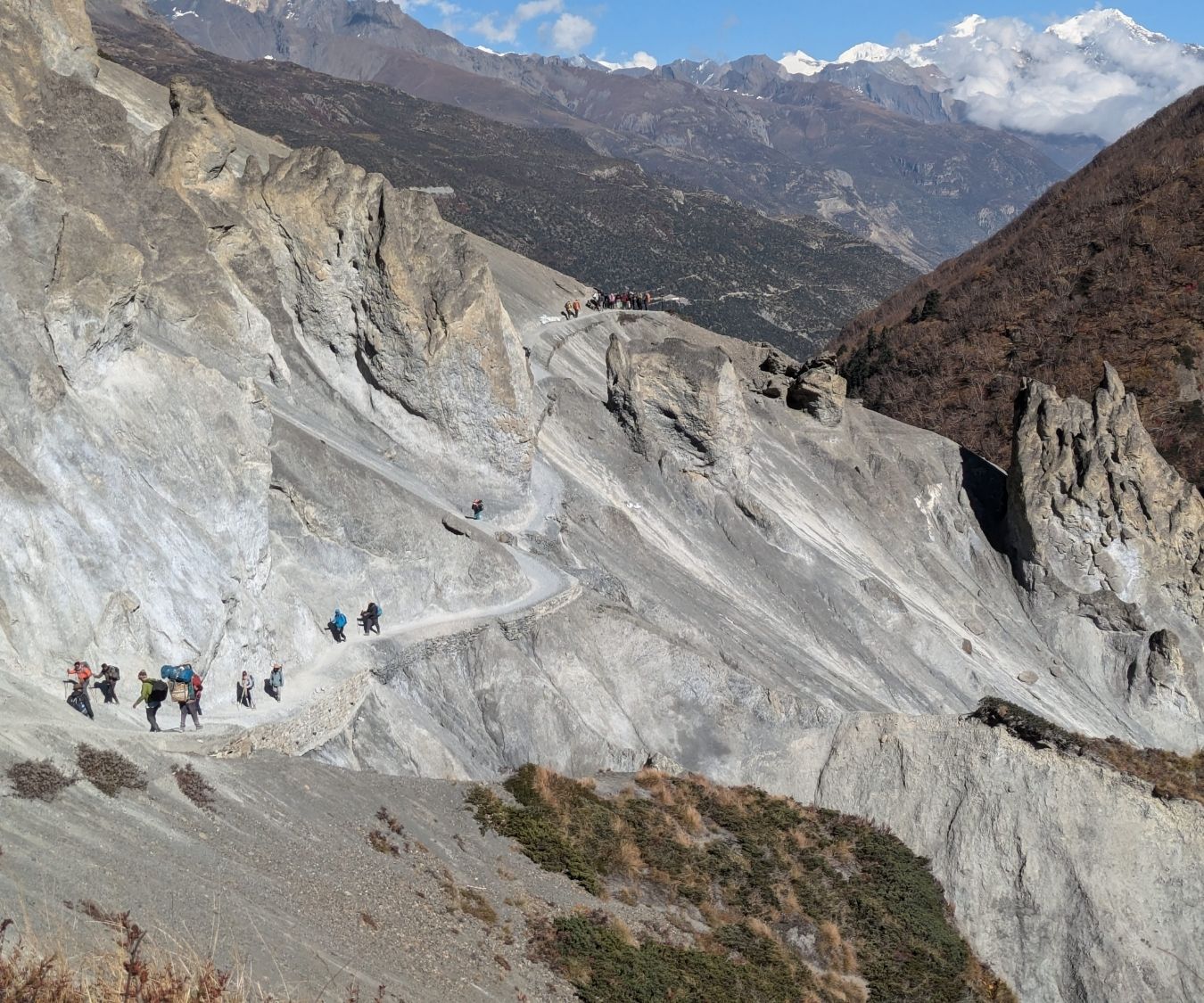 Travelers making their way along the dramatic cliffside trails of the Annapurna Circuit in Nepal