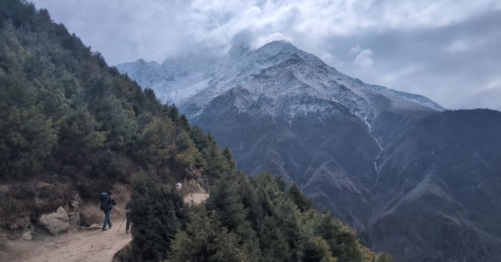 Hikers walking the EBC trail in October with snow on mountain peaks