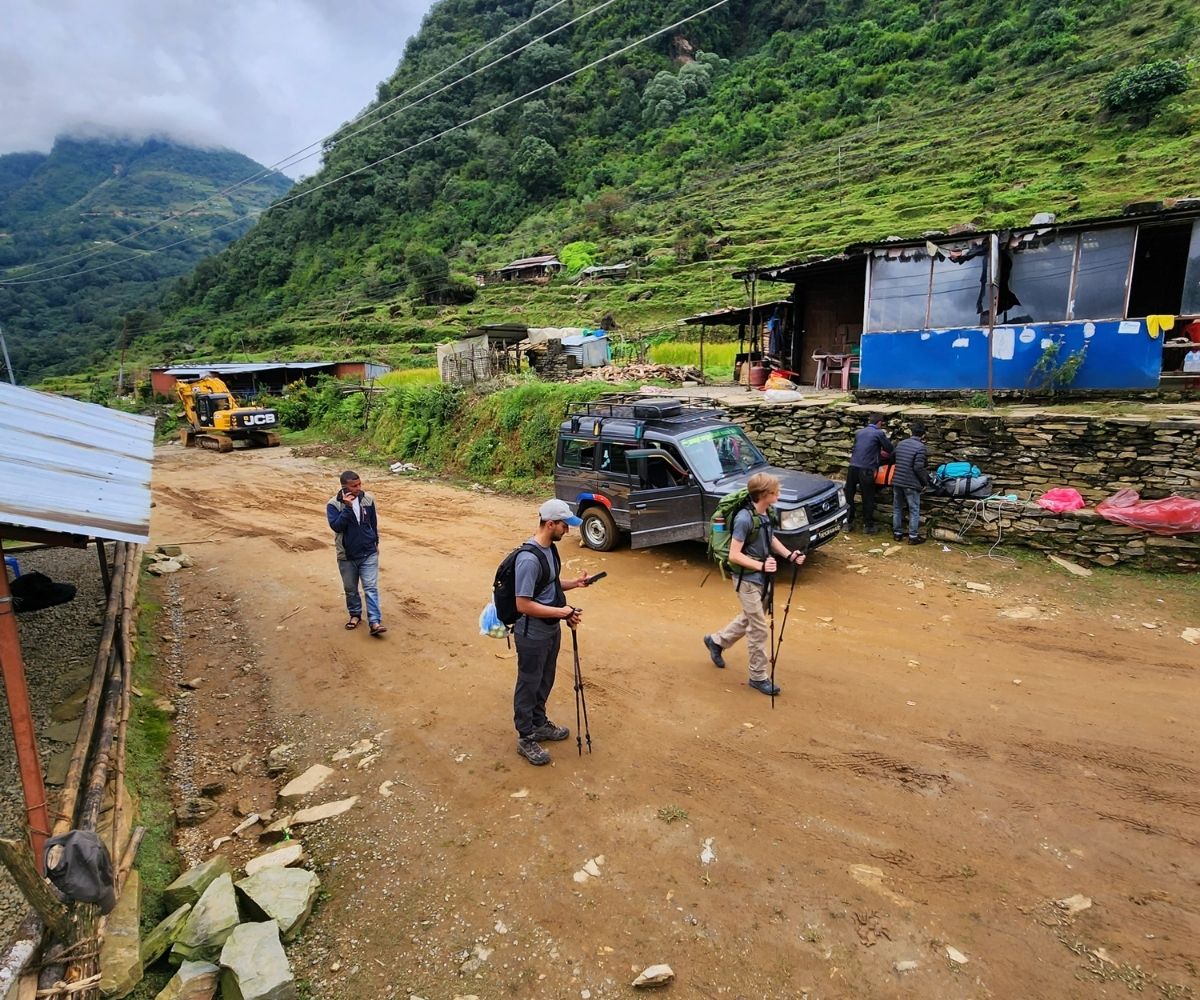 Start point for nepal travel in rural Nepal with hikers preparing beside jeeps