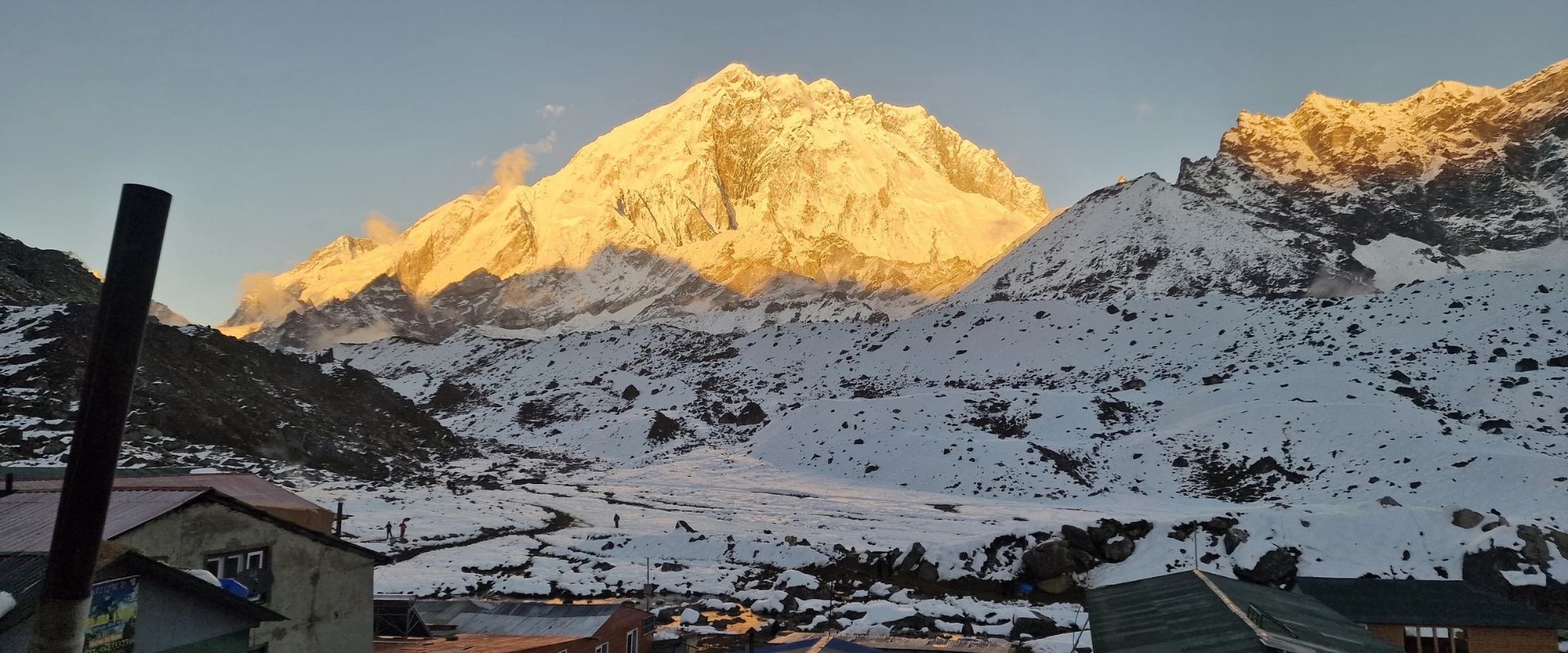 Golden sunrise light illuminating snow-covered Mount Everest and nearby peaks