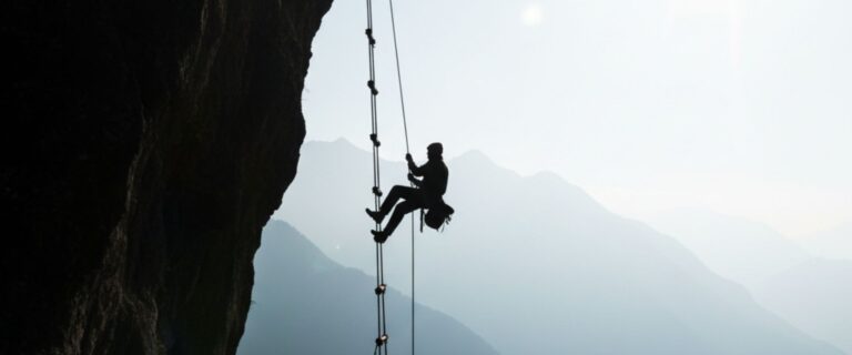 Nepalese mad honey hunter's silhouette against bright sky