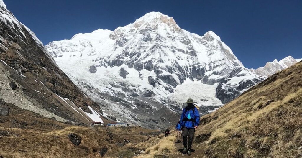 Trekker walking toward snowy Annapurna Base Camp trail