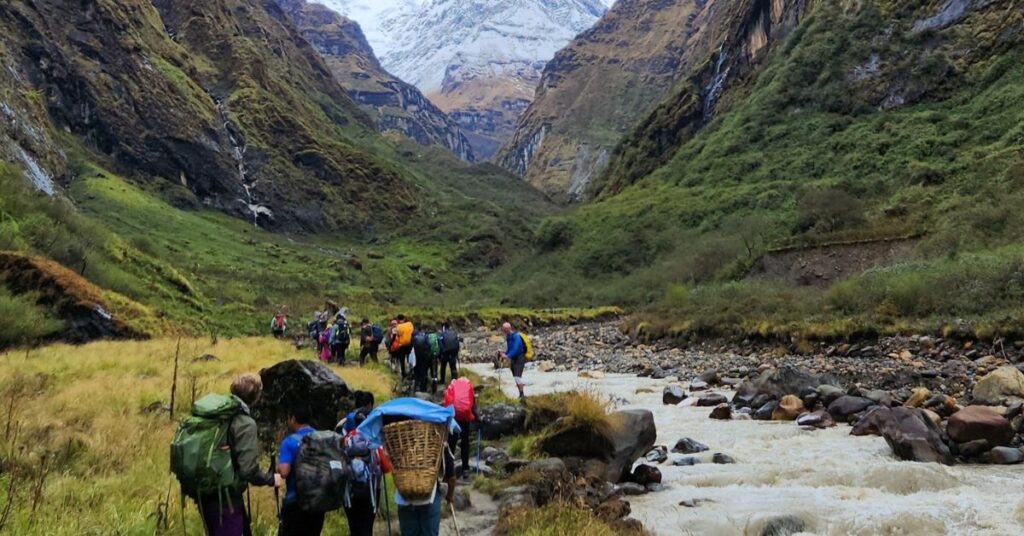Trekkers ascend through a high-altitude valley toward Annapurna Base Cam