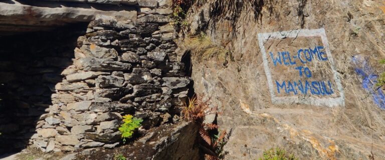 Welcome to Manaslu sign painted on rock along the trail