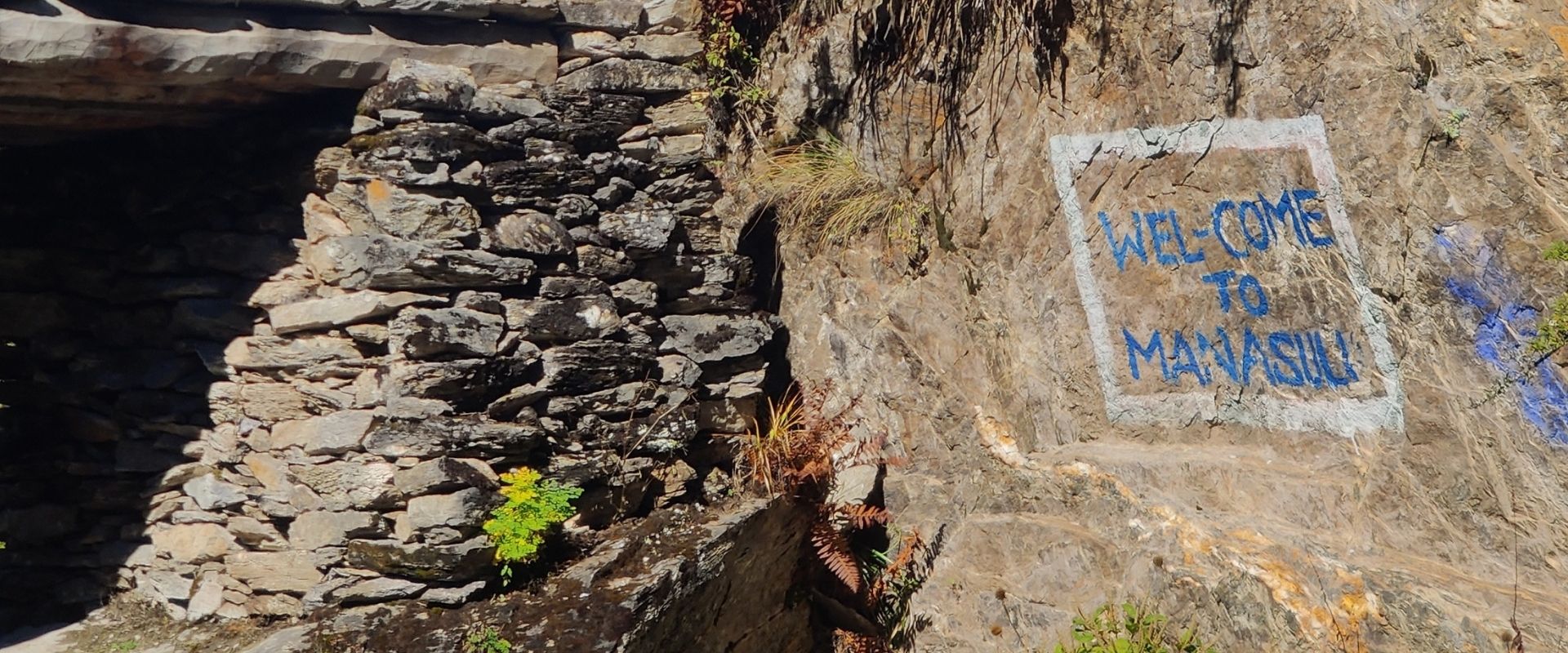 Welcome to Manaslu sign painted on rock along the trail