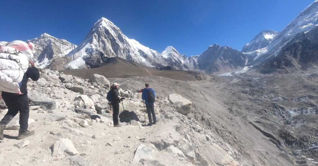 traveler with porter and guide on everest trek